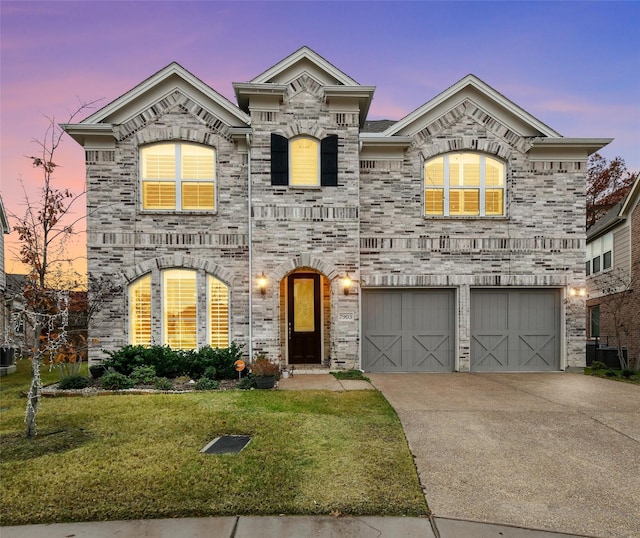 view of front of home with a garage and a lawn