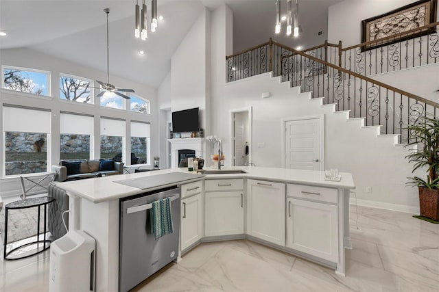 kitchen featuring stainless steel dishwasher, decorative light fixtures, a kitchen island with sink, and white cabinets