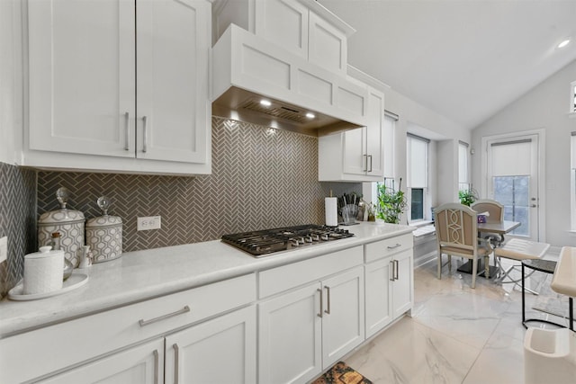 kitchen with white cabinetry, backsplash, vaulted ceiling, and stainless steel gas stovetop