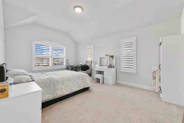 bedroom with lofted ceiling and light carpet