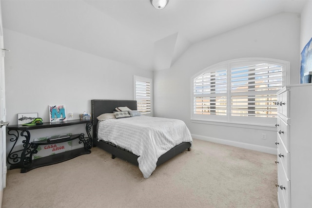 bedroom with vaulted ceiling and light carpet