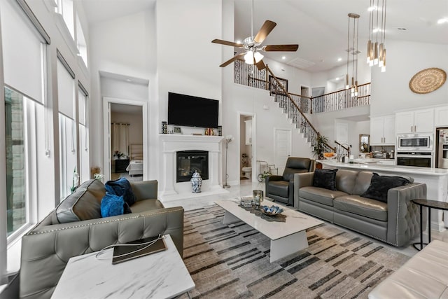 living room with ceiling fan, a healthy amount of sunlight, and a high ceiling