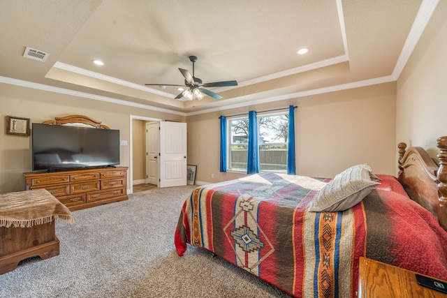 carpeted bedroom featuring a tray ceiling, ceiling fan, and crown molding