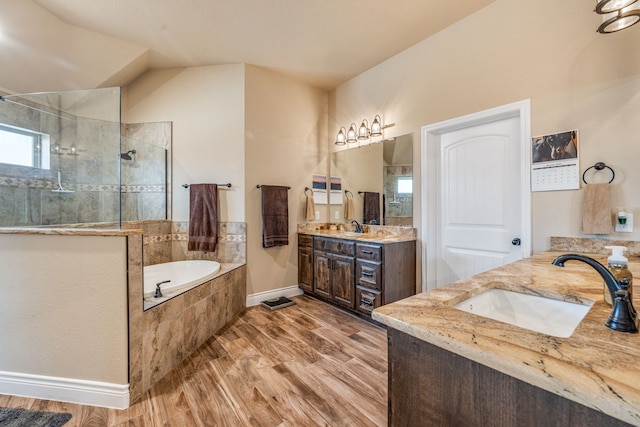 bathroom featuring plus walk in shower, hardwood / wood-style floors, and vanity