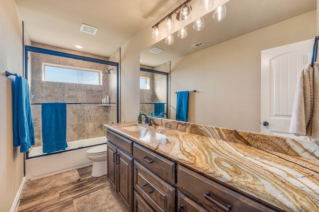 full bathroom featuring vanity, shower / bath combination with glass door, toilet, and wood-type flooring