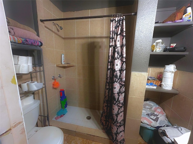 bathroom featuring a shower with shower curtain, toilet, and tile walls