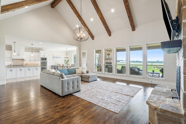 living room featuring beamed ceiling, wood-type flooring, high vaulted ceiling, and an inviting chandelier