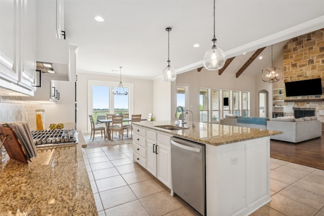 kitchen with dishwasher, a center island with sink, sink, light stone counters, and white cabinetry