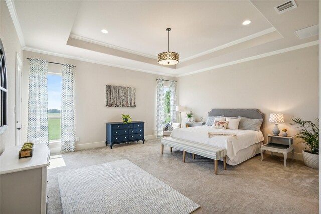 carpeted bedroom with a tray ceiling and ornamental molding