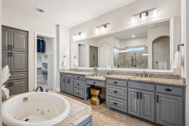 bathroom with tile patterned floors, vanity, and tiled shower