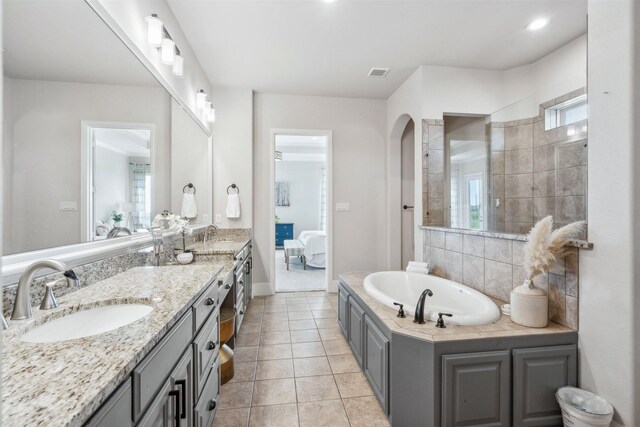 bathroom featuring tile patterned flooring, vanity, and a bath