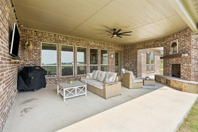 view of patio / terrace with an outdoor living space with a fireplace and ceiling fan