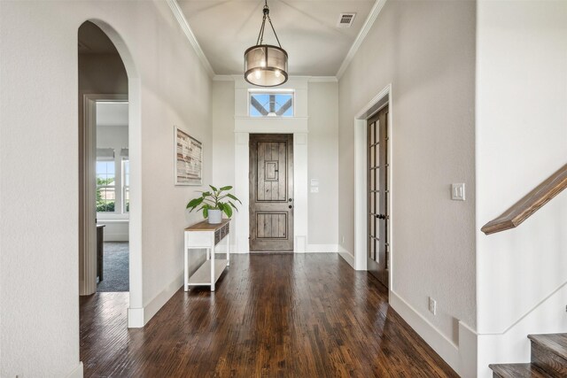 foyer featuring dark hardwood / wood-style floors, crown molding, a high ceiling, and french doors