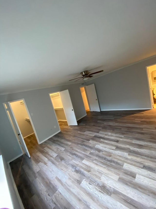 unfurnished living room featuring wood-type flooring, ceiling fan, and crown molding