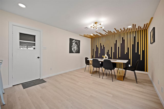 dining room featuring light wood-type flooring and a notable chandelier