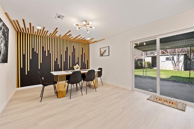 dining space featuring light hardwood / wood-style flooring and a chandelier