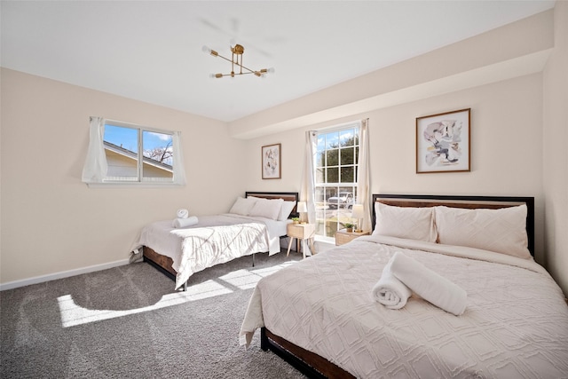 carpeted bedroom featuring multiple windows and a chandelier