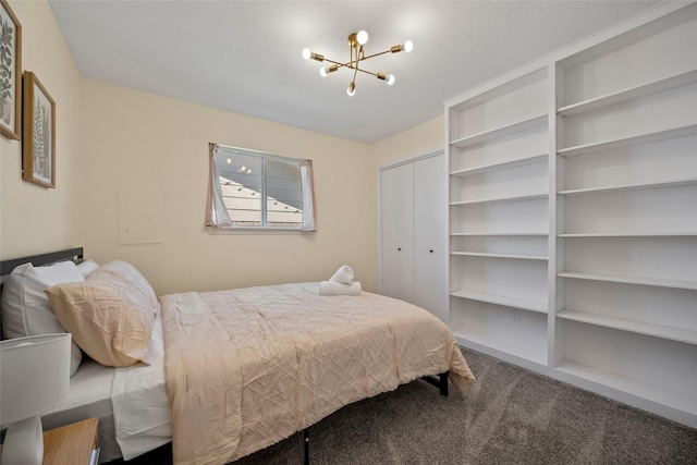 carpeted bedroom with a notable chandelier and a closet