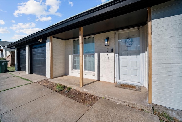 doorway to property with a garage and covered porch