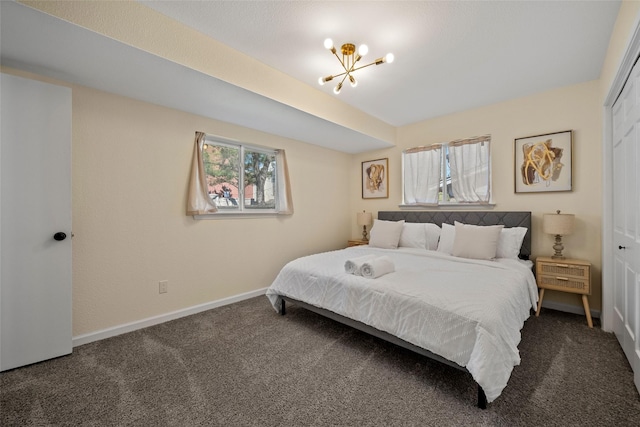 carpeted bedroom with a closet and a notable chandelier