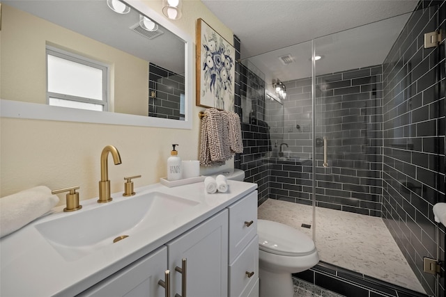 bathroom featuring a textured ceiling, vanity, toilet, and walk in shower