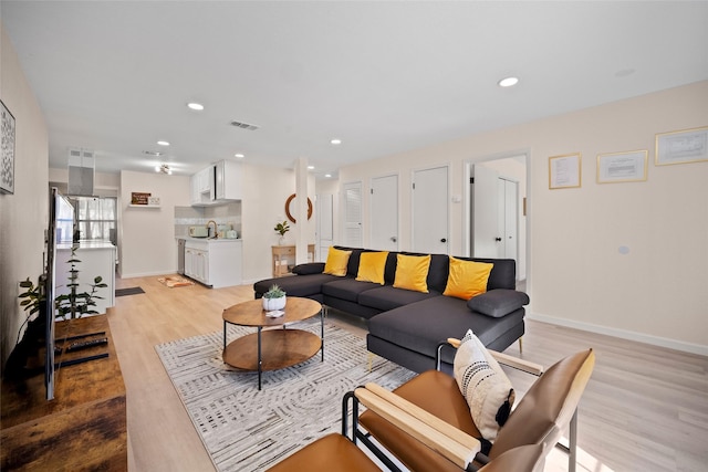 living room featuring light hardwood / wood-style flooring and sink