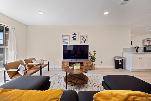 living room featuring light wood-type flooring and a wealth of natural light