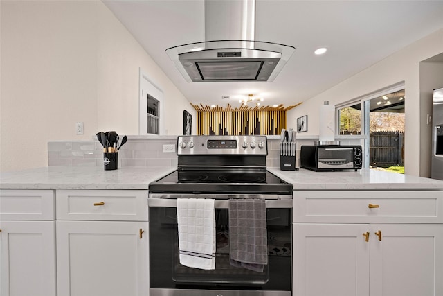 kitchen with stainless steel electric stove, white cabinets, light stone countertops, and island exhaust hood