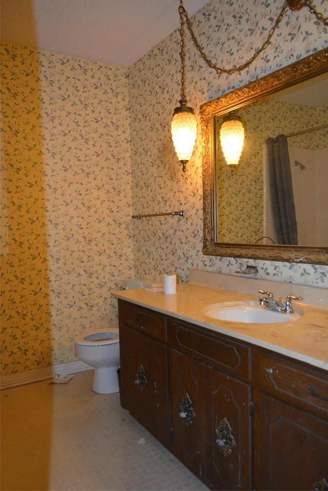 bathroom with tile patterned flooring, vanity, and toilet