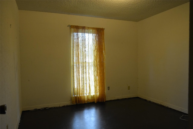 unfurnished room with a textured ceiling