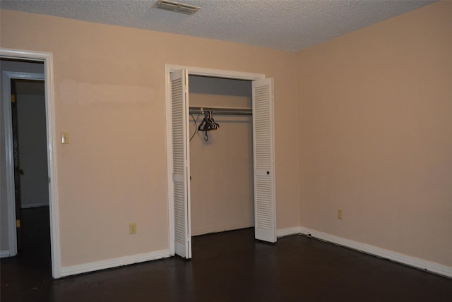 unfurnished bedroom featuring a textured ceiling and a closet