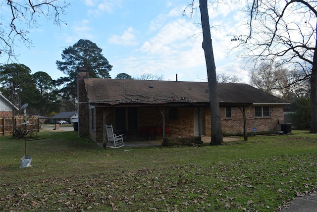 rear view of property with a yard