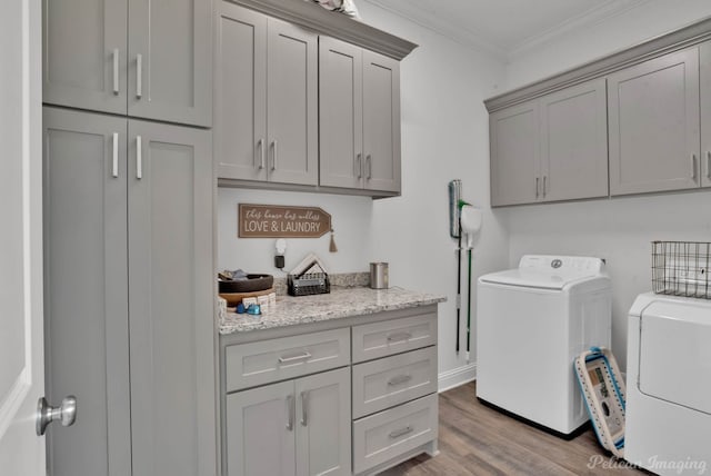 clothes washing area with independent washer and dryer, cabinets, crown molding, and light wood-type flooring