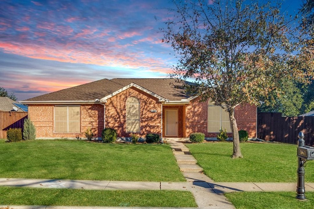 ranch-style home with a lawn