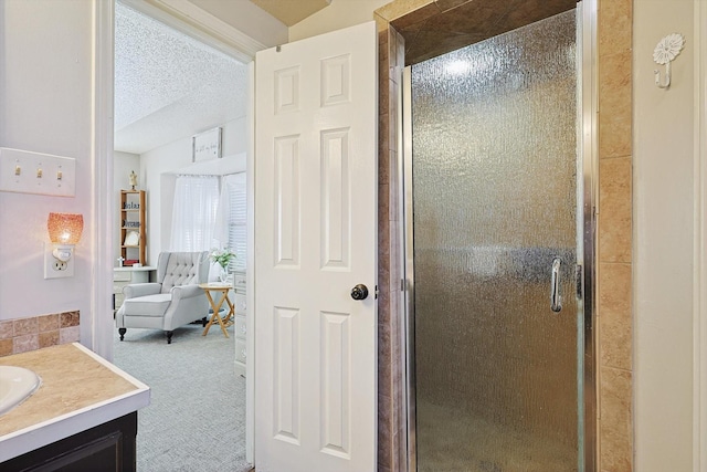 bathroom with vanity, a textured ceiling, and walk in shower