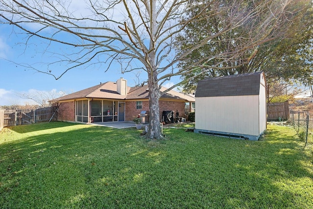 back of house with a patio area, a yard, and a storage shed