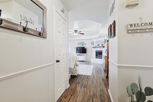 hallway with dark hardwood / wood-style flooring and a textured ceiling