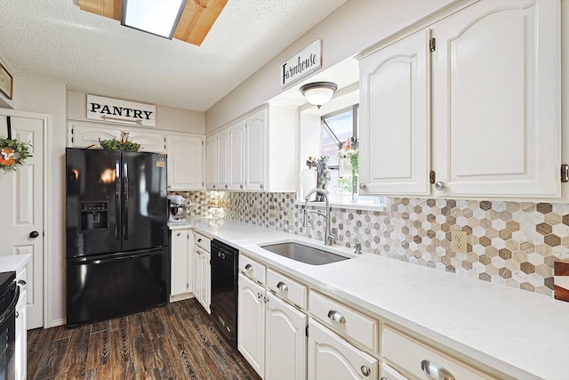 kitchen with black appliances, white cabinetry, and sink