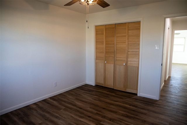 unfurnished bedroom featuring a closet, dark wood-type flooring, and ceiling fan