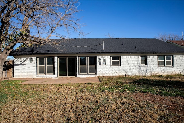 rear view of house with a lawn and a patio