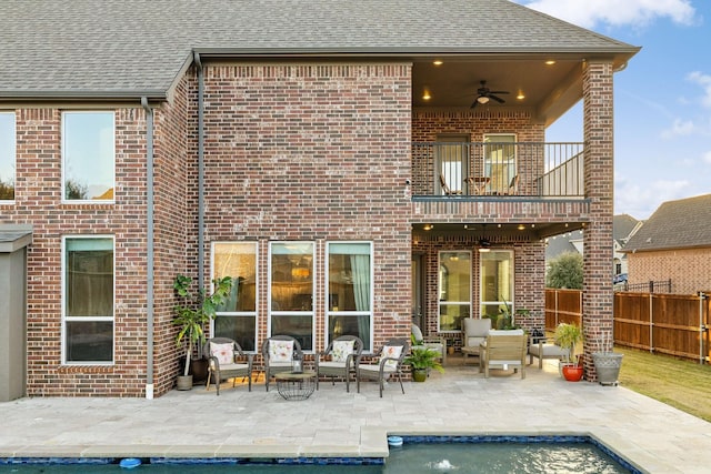 back of house featuring an outdoor living space, a patio, a balcony, and ceiling fan