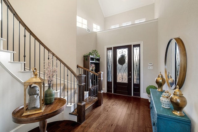 entrance foyer featuring dark wood-type flooring and high vaulted ceiling