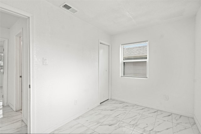 unfurnished room with a textured ceiling