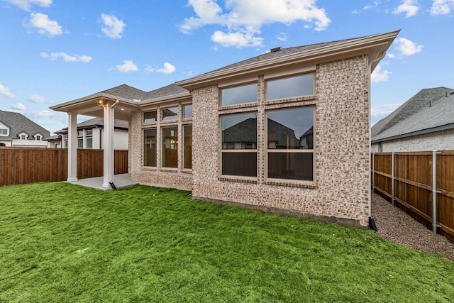 rear view of property featuring a lawn