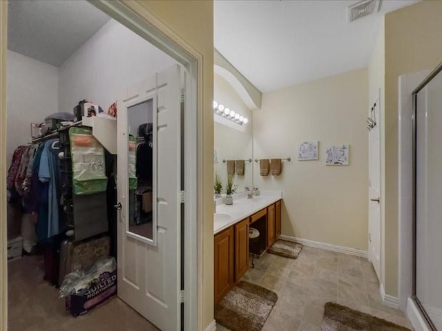 bathroom with a shower with door and vanity