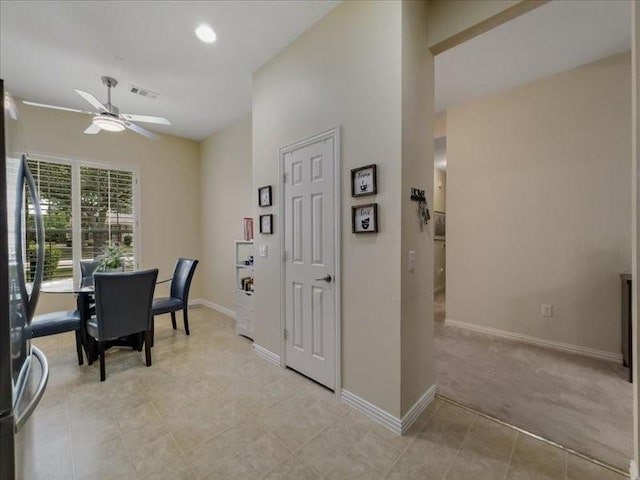 dining area featuring ceiling fan and light carpet