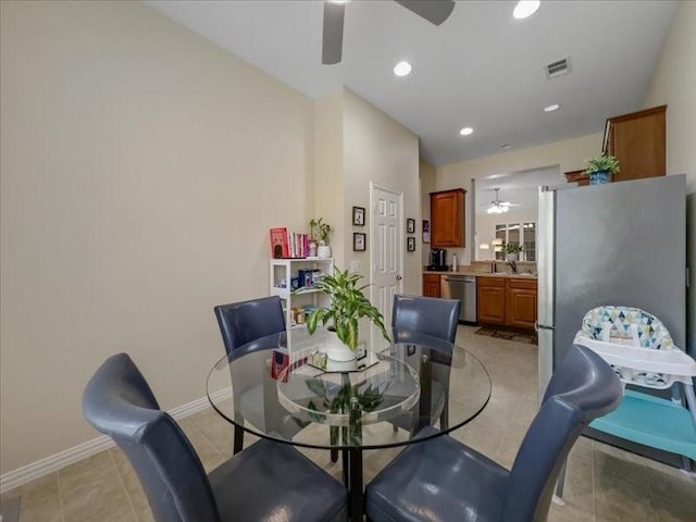 dining space with ceiling fan, sink, and light tile patterned floors