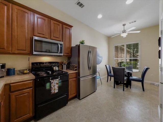 kitchen with ceiling fan, appliances with stainless steel finishes, and tile counters