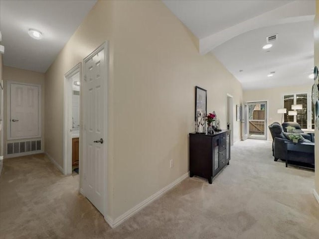 corridor with beamed ceiling and light colored carpet