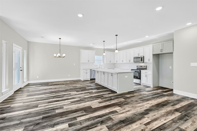 kitchen with white cabinetry, stainless steel appliances, a kitchen island, and pendant lighting